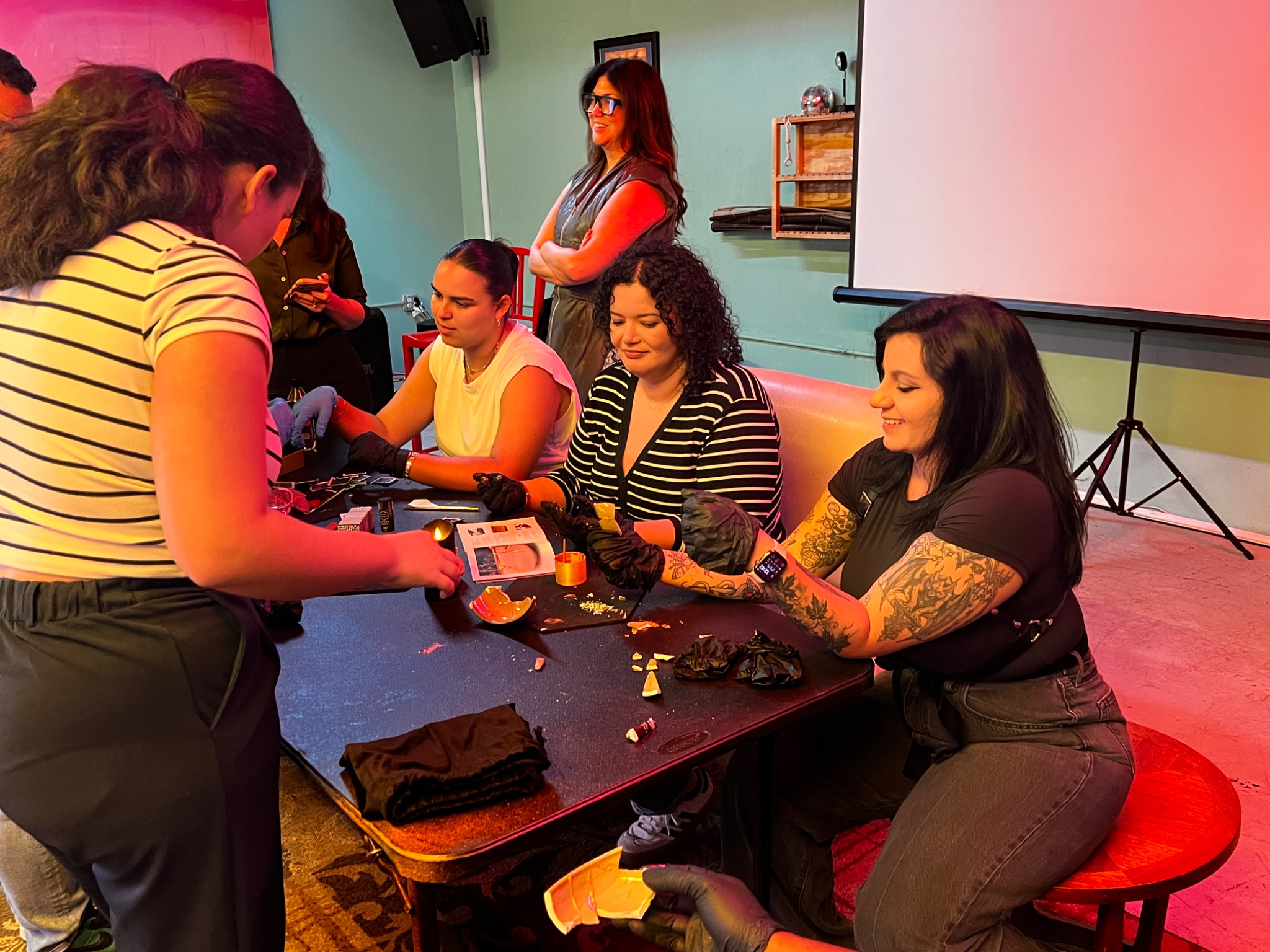 Participants gathering around a table and working with colorful materials during a HUEMUNS chamber
